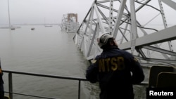 Un trabajador de la Junta Nacional de Seguridad en el Transporte (NTSB) observa el buque de carga Dali, que chocó y derrumbó el puente Francis Scott Key, en Baltimore, Maryland, EEUU, el 27 de marzo de 2024.