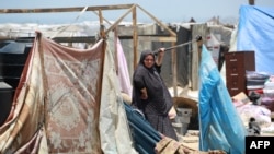 Una mujer palestina desplazada junto a sus pertenencias mientras la gente evacua el área de Mawassi en las afueras del suroeste de Khan Yunis en el sur de la Franja de Gaza el 28 de junio de 2024, en medio del conflicto en curso entre Israel y el grupo militante Hamas.