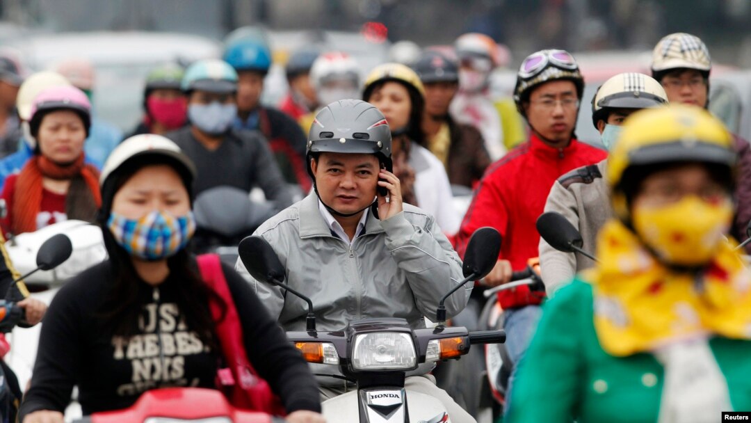 FILE - A motorist talks on his mobile phone while waiting at a traffic junction in Hanoi in this 2011 photo.