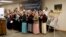Una foto del grupo de los diecisiete rehenes liberados se ve junto al podio mientras los miembros del personal de Christian Aid Ministries cierran una conferencia de prensa cantando "Nearer My God to Thee" en la oficina central de Christian Aid Ministries en Berlín, Ohio.