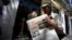 FILE - A vendor holds a copy of Cuba's state newspaper Granma, in Havana, Cuba, Aug. 13, 2015. 