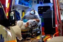 FILE - A man lies in an ambulance at a hospital in Papeete, Tahiti, French Polynesia, Aug. 20, 2021. France's worst virus outbreak so far is unfolding 12 times zones away from Paris, devastating the idyllic atolls of French Polynesia.