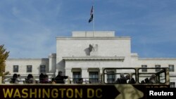 Un autobús de turistas pasa frente al edificio de la Reserva Federal en Washington, D.C.
