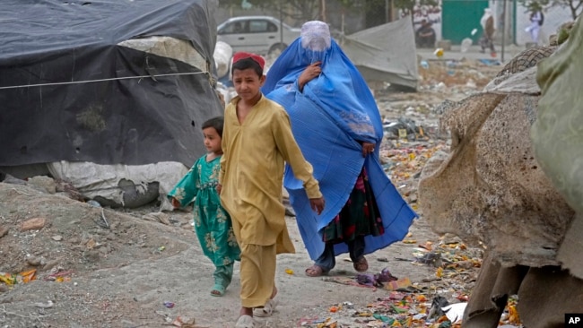 A woman walks in Kabul on Sunday wearing a burqa. The Taliban government said all women must cover their entire body when they are walking outside their homes. (AP Photo/Ebrahim Noroozi)