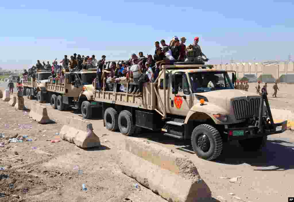 Iraqi men fill military trucks to join the Iraqi army at the main recruiting center in Baghdad, June 17, 2014.