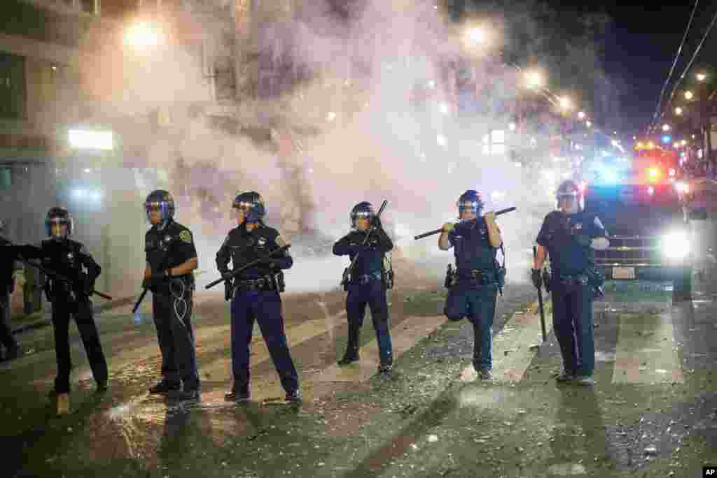 San Francisco police officers attempt to break up a large crowd celebrating after the San Francisco Giants won the World Series baseball game against the Kansas City Royals, San Francisco, Oct. 29, 2014. 