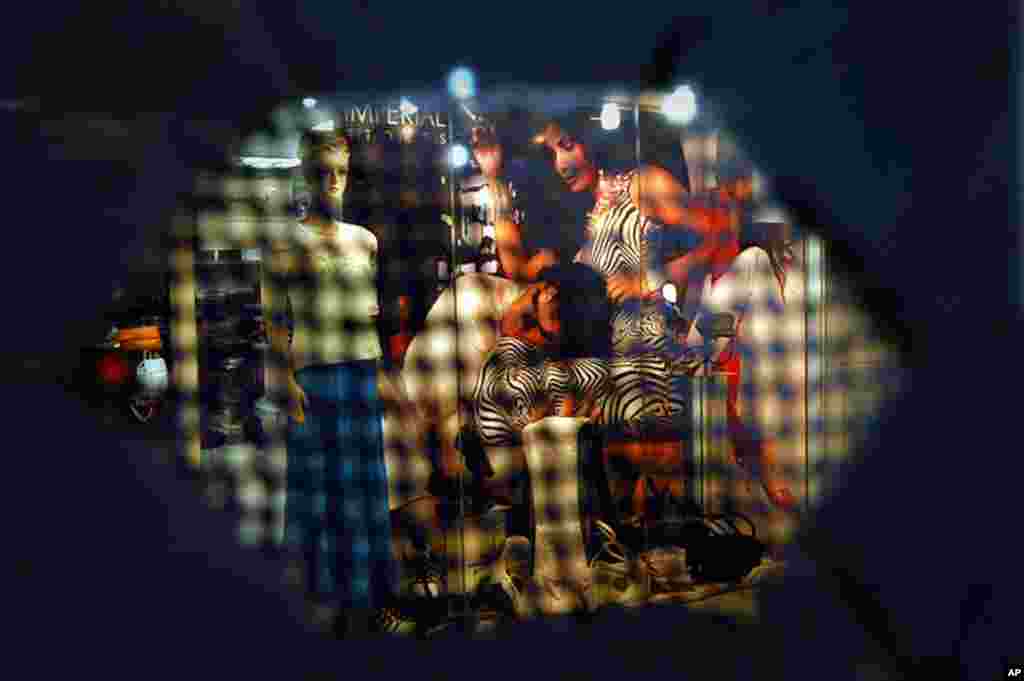 This photograph is taken through the eye-hole webbing of a burqa veil in front of a clothing store in Kabul, Afghanistan on Thursday, May 3, 2007. (AP)