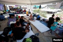 Solicitantes de asilo, en su mayoría de Venezuela, descansan a la sombra de una carpa instalada por las autoridades mexicanas cerca de la frontera mientras intentan cruzar a EEUU sin cita previa, en Nuevo Laredo, México, el 27 de junio de 2023. REUTERS/Daniel Becerril