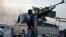 Fighters of the Islamic State of Iraq and the Levant (ISIL) stand guard at a checkpoint in the northern Iraq city of Mosul, June 11, 2014.