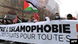 Para pengunjuk rasa membentangkan spanduk dan bendera Palestina dalam unjuk rasa menentang RUU "antiseparatisme" dan Islamofobia di Paris, Perancis, 21 Maret 2021. (Foto: Alain Jocard/AFP)