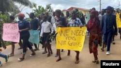 Schoolchildren, their parents and teachers hold a protest after gunmen opened fire at a school in Kumba, Cameroon, Oct. 25, 2020. At a protest in Yaounde, Cameroon, Tuesday, teachers called for better protection against violence and attacks.