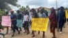 Schoolchildren, their parents and teachers hold a protest after gunmen opened fire at a school, killing at least six children as authorities claim, in Kumba, Cameroon, Oct. 25, 2020.