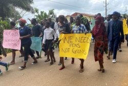 FILE - Schoolchildren, their parents and teachers hold a protest after gunmen opened fire at a school, killing at least six children as authorities claim, in Kumba, Cameroon, Oct. 25, 2020.