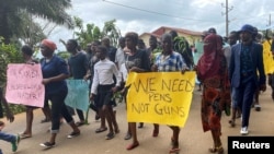 Schoolchildren, their parents and teachers hold a protest after gunmen opened fire at a school, killing at least six children as authorities claim, in Kumba, Cameroon, Oct. 25, 2020.