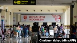 Penumpang yang mengenakan masker wajah sebagai protokol keamanan terhadap Covid-19 terlihat di Bandara Internasional Sultan Iskandar Muda di Blang Bintang, pada 25 April 2021. (Foto: AFP/Chaideer Mahyuddin) 