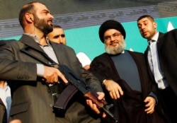 FILE - Lebanon's Hezbollah leader Sayyed Hassan Nasrallah (2nd R), escorted by his bodyguards, greets his supporters at an anti-U.S. protest in Beirut's southern suburbs.