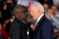 Democratic presidential candidate former Vice President Joe Biden talks to Rep. James Clyburn, D-S.C., at a primary night election rally in Columbia, S.C., Feb. 29, 2020 after winning the South Carolina primary.