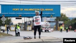 A dockworker demonstrates after a shipping port strike went into effect across the East Coast at the Port of Wilmington, Del., Oct. 1, 2024