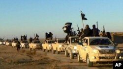 FILE - Militants of the Islamic State are seen near Raqqa, Syria, on a road leading to Iraq. The undated file photo was released by a militant website, which has been verified and is consistent with other AP reporting. 