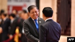 Myanmar's secretary of foreign affairs, Aung Kyaw Moe, left, shakes hands with Laotian Foreign Minister Saleumxay Kommasith during the ASEAN meeting in Vientiane, Laos, on July 25, 2024. 