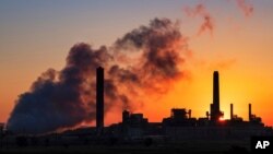 FILE - The Dave Johnson coal-fired power plant is silhouetted against the morning sun in Glenrock, Wyo., July 27, 2018.