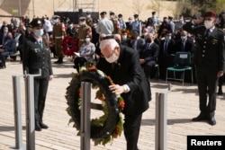 Presiden Israel Reuven Rivlin memberikan penghormatan selama upacara peletakan karangan bunga menandai Hari Peringatan Holocaust di Warsawa Ghetto Square di peringatan Yad Vashem di Yerusalem, 8 April 2021. (Foto: Maya Alleruzzo via REUTERS)