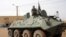 Fighters of the Islamic group, the Movement for Oneness and Jihad in West Africa [MUJAO] - an Al-Qaida offshoot - stand guard on a tank abandoned by the Malian Army, near Gao airport, Mali, August 7, 2012.