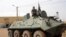 Fighters of the Islamic group, the Movement for Oneness and Jihad in West Africa (MUJAO) - an Al-Qaida offshoot - stand guard on a tank abandoned by the Malian Army, near Gao airport, Mali, August 7, 2012.