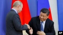 Presiden China Xi Jinping dan Presiden Rusia Vladimir Putin bersalaman dalam upacara pemberian gelar kehormatan kepad Presiden Xi dari Universitas Negeri St. Petersburg di St. Petersburg, Rusia, 6 Juni 2019. 