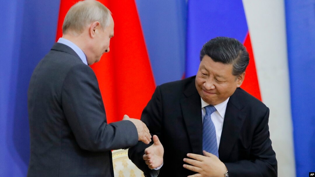 Presiden Rusia Vladimir Putin berjabat tangan dengan Presiden China Xi Jinping di St. Petersburg State University, St. Petersburg, Rusia hari Rabu (6/6). 