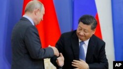 Presiden Rusia Vladimir Putin berjabat tangan dengan Presiden China Xi Jinping di St. Petersburg State University, St. Petersburg, Rusia hari Rabu (6/6). 