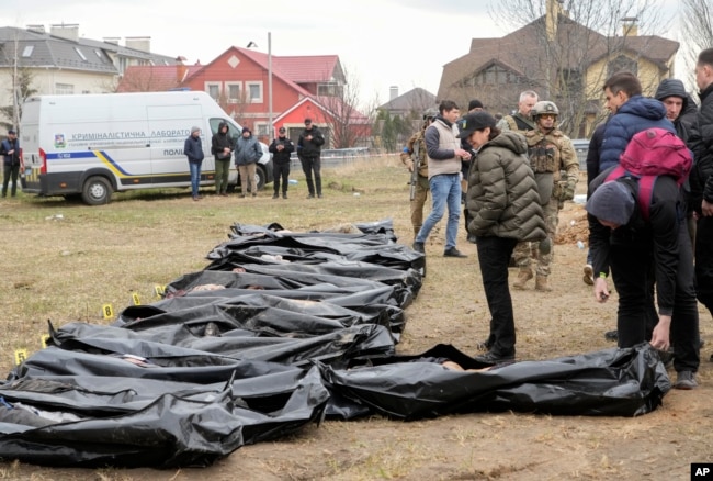 Ukrainian Prosecutor General Iryna Venediktova, center, looks at the exhumed bodies of civilians killed during the Russian occupation in Bucha, on the outskirts of Kyiv, Ukraine, Friday, April 8, 2022. (AP Photo/Efrem Lukatsky, File)