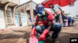 A health worker wearing protective gear mixes water and chlorine in Goma, July 31, 2019. A second person has died of Ebola in the eastern DR Congo city.