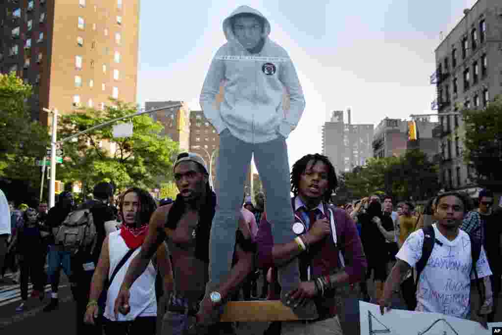 Waandamanaji wakitembea katika mtaa wa Lower East Side mjini New York huku wakiwa wameshikilia sanamu la Trayvon Martin wakati wa maandamano baada ya kuachiwa kwa George Zimmerman, July 14, 2013.