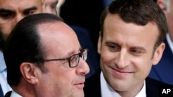 Le président français sortant François Hollande, à gauche, discute avec le président élu Emmanuel Macron lors de la cérémonie de la commémoration de l’abolition de l’esclavage, à Paris, France, 10 mai 2017.