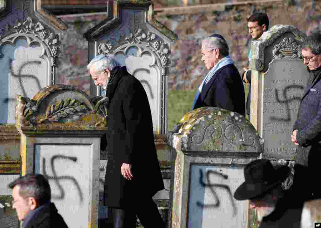 Members of the Jewish community walk amid vandalized tombs in the Jewish cemetery of Westhoffen, west of the city of Strasbourg, France.