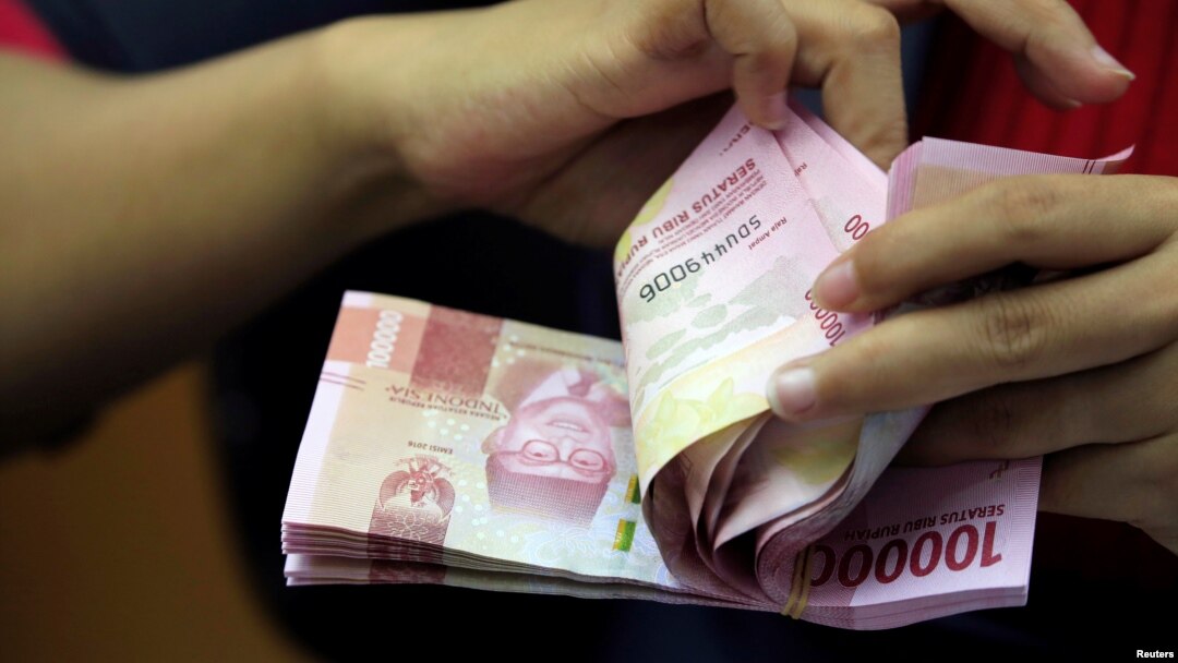 Seorang karyawan tengah menghitung lembaran uang kertas rupiah di sebuah tempat penukaran uang di Jakarta, 23 Oktober 2018. (REUTERS/Beawiharta). 