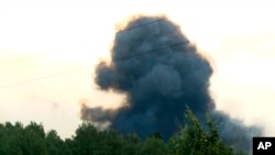 In this video grab provided by the RU-RTR Russian television, smoke rises after explosions at the military base, about 10 kilometers from Achinsk, Krasnoyarsk region, Russia Far East, Aug. 5, 2019. 
