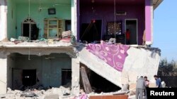 Residents look for belongings amid damage from what activists said were airstrikes by forces of Syria's President Bashar al-Assad in Saida village, in Deraa province, Feb. 1, 2015.