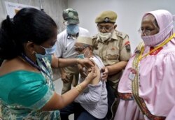A man receives a dose of COVISHIELD, a coronavirus vaccine manufactured by Serum Institute of India, at a vaccination center in Mumbai, India, May 6, 2021.