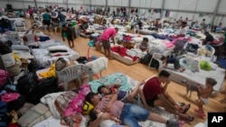 People who evacuated their flooded homes rest in a shelter amid heavy rain in Porto Alegre, Rio Grande do Sul state, Brazil, May 8, 2024.