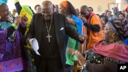 FILE - In this Saturday, July 4, 2015 file photo retired Anglican Archbishop Desmond Tutu, centre, breaks into dance after renewing his wedding vows to his wife of 60 years, Leah (r) during a service in Soweto, Johannesburg.