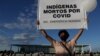 Seorang demonstran membawa poster bertuliskan suku asli Indian di Brazil yang banyak menjadi korban COVID-19. 