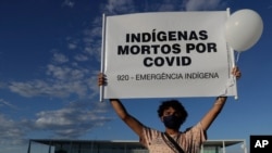 A demonstrator shows a sign reading 'Indians Killed by COVID' during a protest over Brazil's response to the coronavirus pandemic in front of the presidential palace in Brasilia, Brazil, Jan. 21, 2021.