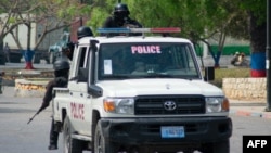 FILE - Armed police officers monitor the area after gang violence in the neighborhood on the evening of March 21, 2024, in Port-au-Prince, Haiti, March 22, 2024.