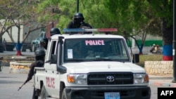 FILE - Armed police officers monitor the area after gang violence in the neighborhood on the evening of March 21, 2024, in Port-au-Prince, Haiti.