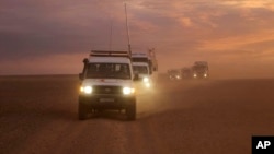 This photo released by the Syrian Arab Red Crescent, shows a convoy of vehicles of the Syrian Arab Red Crescent driving in the Syrian desert heading to Rukban camp between the Jordan and Syria borders, Nov. 4, 2018.