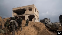 FILE - Israeli soldiers stand outside a building during the ground offensive on the Gaza Strip in Khan Younis, January 27, 2024.