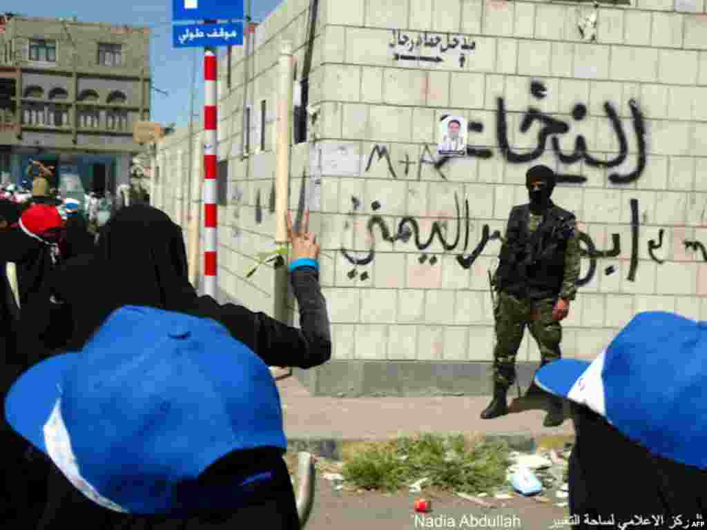 A protester flashes a peace sign at a soldier. (Photo - Nadia Abdullah)