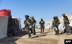 FILE - An image obtained from the media office of the Kurdish People's Protection Units in Syria (YPG) on March 29, 2021, shows YPG forces conducting a security operation the previous day at the Kurdish-run al-Hol camp. (AFP PHOTO/HO/YPG)